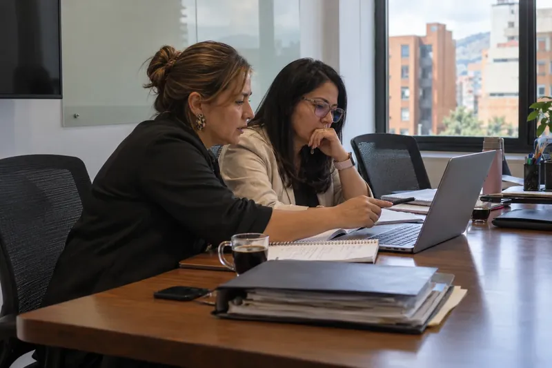 Programa de mentoría: mentora y coordinadora revisan juntas el avance de un caso real de la empresa